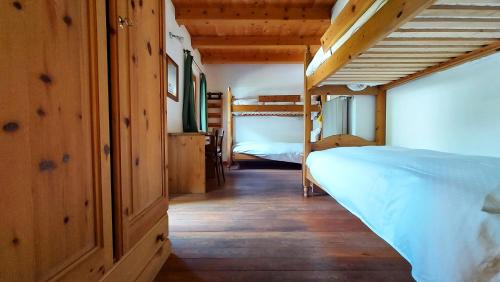 a bedroom with two bunk beds and wooden walls at La Sloda in Forno di Zoldo