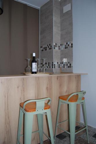 two chairs sitting next to a counter with a bottle of wine at Apartamentos Los Jardines& Parking in Córdoba