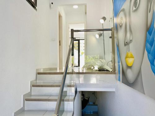 Baño con escalera con espejo y lavabo en Beach Bungalow Holiday Home, en Adeje