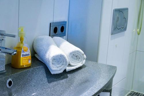lavabo en el baño con toallas en la encimera en Strandhochhaus SB11, en Cuxhaven