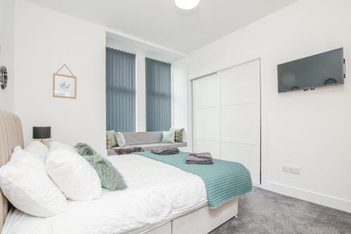 biała sypialnia z łóżkiem i kanapą w obiekcie Mansfield Bar w mieście Hawick
