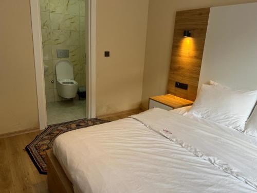 a bedroom with a bed and a bathroom with a toilet at Karadeniz Apart Otel in Uzungol