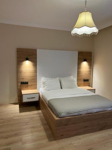 ein Schlafzimmer mit einem großen Bett und einem Kronleuchter in der Unterkunft Karadeniz Apart Otel in Uzungöl