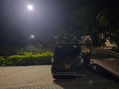 a car parked in a parking lot at night at Airport Side Hotel Entebbe in Entebbe