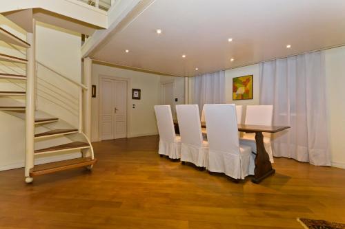 a dining room with a table and white chairs at N 10, Luxury in Turin