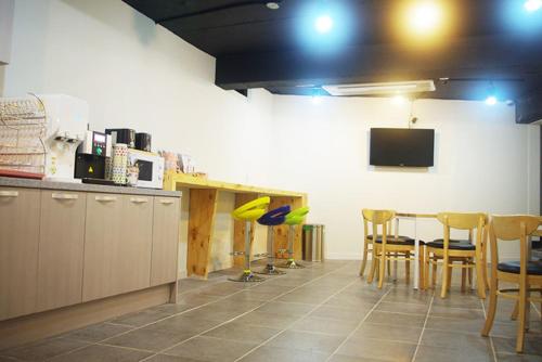 cocina con mesa y sillas y TV en 24 Guest House Yeosu en Yeosu