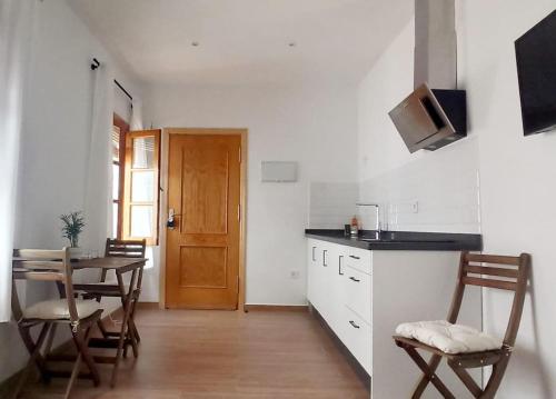 uma cozinha e sala de jantar com mesa e cadeiras em Limerencia: tu hogar en este blanco pueblo em Frigiliana
