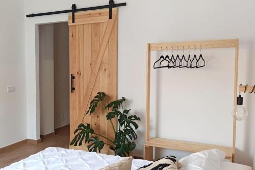 um quarto com uma porta de madeira e uma cama em Limerencia: tu hogar en este blanco pueblo em Frigiliana