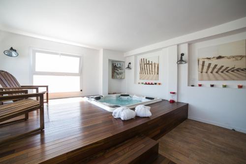 a bathroom with a bath tub on a wooden floor at La Villa en L'île - 2 Piscines & Spa in Noirmoutier-en-l'lle