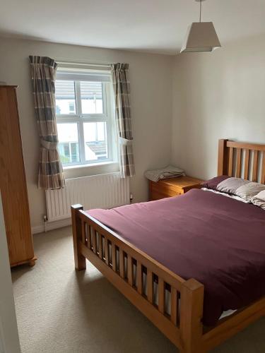 a bedroom with a bed and a window at Ballycastle, Strand Cottages Modern Home in Ballycastle