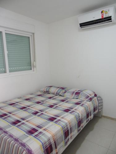 a bed in a white room with a window at Flat 404 Villa Hipica in Gravatá