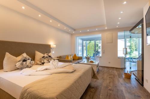 a bedroom with a large bed and a living room at Promenaden-Strandhotel Marolt in Sankt Kanzian