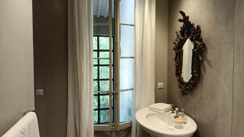 a bathroom with a sink and a mirror and a window at Le Complot : Maison privée en plein coeur d'Avignon in Avignon