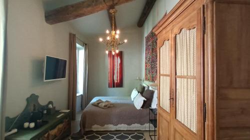 sypialnia z łóżkiem i żyrandolem w obiekcie Le Complot : Maison privée en plein coeur d'Avignon w Awinionie