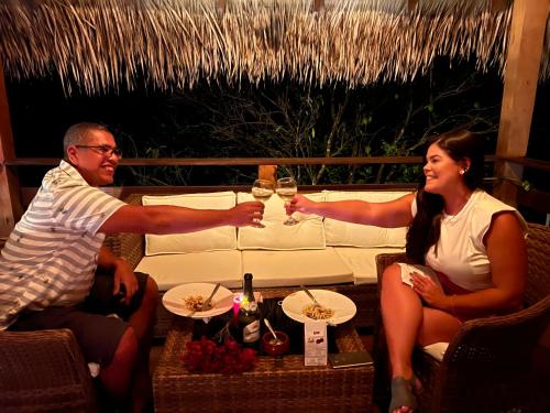 a man and woman sitting around a table with glasses of wine at Villa Éden in Alter do Chao