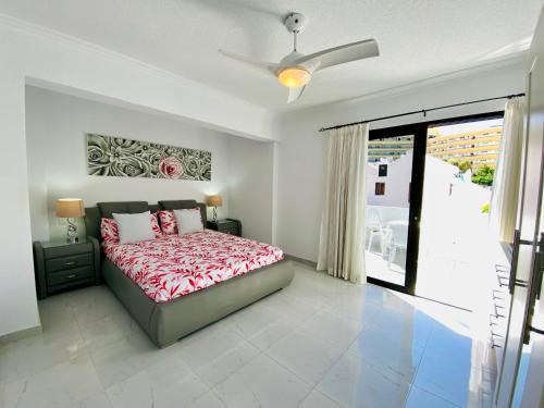 1 dormitorio con 1 cama y ventilador de techo en Beach Bungalow Holiday Home, en Adeje