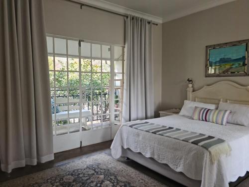 a bedroom with a bed and a sliding glass door at Maria's in Melville in Johannesburg