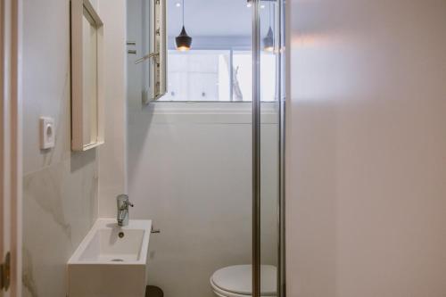 a bathroom with a toilet and a sink and a window at The Lx Hill in Lisbon