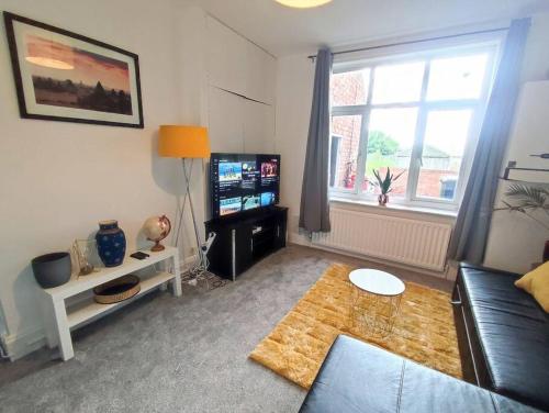 a living room with a couch and a television at Northern Breeze Apartment in Cambois