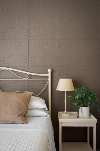 a bedroom with a bed with a lamp and a plant at Hotel Giardino Suites&Spa in Numana