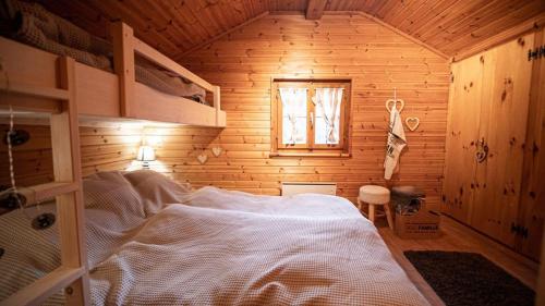 AyerにあるChalet Bella Vouarda. Cosy traditional alpine stayの木製の部屋にベッド1台が備わるベッドルーム1室があります。