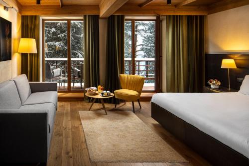 um quarto de hotel com uma cama e um sofá em Ana Hotels Bradul Poiana Brasov em Poiana Brasov