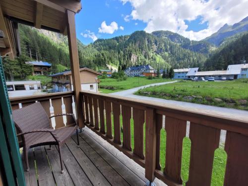 a chair on a porch with a view of a mountain at Tauerndorf Enzingerboden Ski in&out - Steinbock Lodges in Enzingerboden