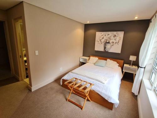 a bedroom with a bed and a chair in it at Palm Zicht MAIN 3 bedroom apartment in Cape Town