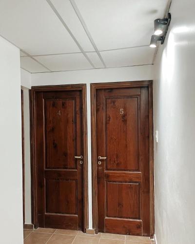 two wooden doors in a room with a wall at Hospedaje Los Ilustres in Tunuyán