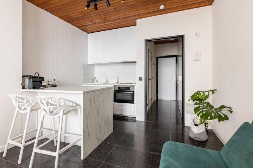 a kitchen with white cabinets and a counter with stools at Riverview Studio in Historical Heart of Antwerp in Antwerp