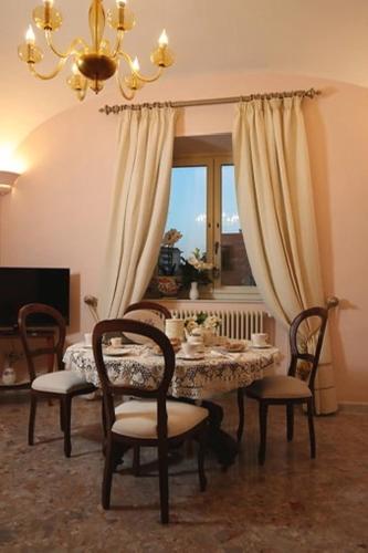 a dining room with a table and chairs and a chandelier at Le Scalelle B&B in Scorpeto