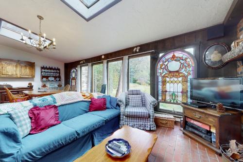 a living room with a blue couch and a tv at Hoot Owl Hollow in Jacksonville