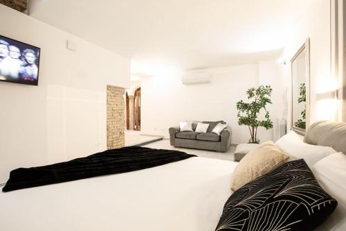 a white bedroom with a large bed and a couch at Memorable Jacuzzi Suite Navona - Top Collection in Rome