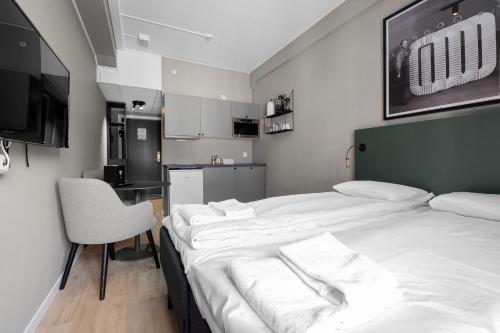 a hotel room with two beds and a kitchen at Forenom Serviced Apartments Drammen in Drammen