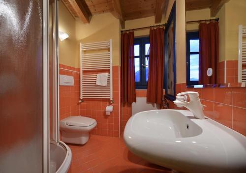 a bathroom with a white sink and a toilet at Casa Cola in Valdidentro