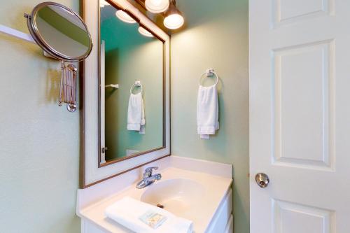 ein Bad mit einem Waschbecken und einem Spiegel in der Unterkunft Beauty And The Beach in St. George Island