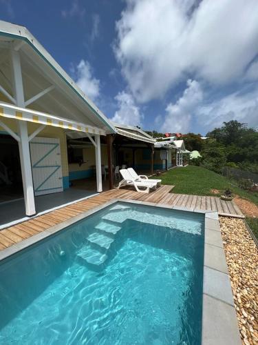 a swimming pool in front of a house at la villa caribéenne de la plage des surfeurs in La Trinité