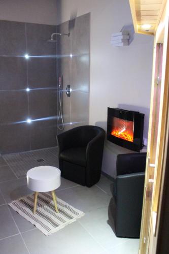 łazienka z kominkiem, krzesłem i prysznicem w obiekcie Maison avec piscine, jacuzzi et sauna privatifs - Mas de Nebbas w Aix-en-Provence