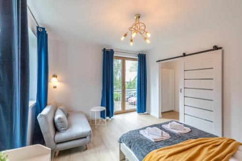 une chambre avec un lit et une chaise dans l'établissement Apartamenty Pod Orzechem z dużym ogrodem - Dream Apart, à Ustroń
