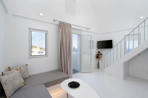 a living room with white walls and a staircase at Cycladic Suites & Spa in Fira