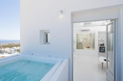a white bathroom with a large bath tub at Cycladic Suites & Spa in Fira