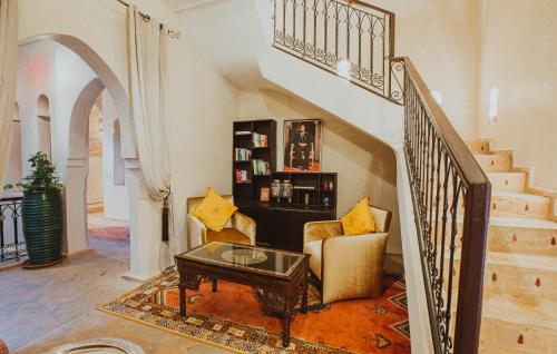a living room with a couch and a table and stairs at Riad El Hara in Marrakech