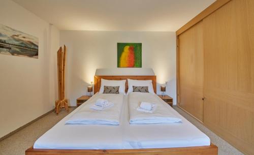 a bedroom with a large white bed with two pillows at Appartement Mountain & Fun in Saalbach Hinterglemm