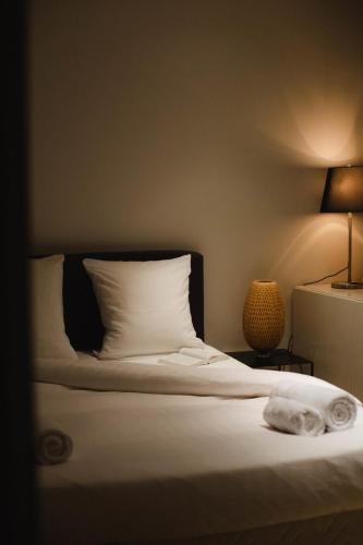 une chambre avec un lit avec des draps blancs et une lampe dans l'établissement La Villa Normande - Studio - Deauville Centre, à Deauville