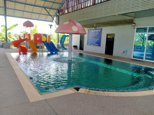 a pool in a building with a playground at Capital O 75412 V Resort in Nakhon Nayok