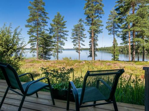2 sillas en una terraza con vistas al lago en Holiday Home Joutsenlampi by Interhome en Joutsa