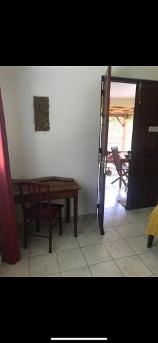 a room with a wooden table and a table and chairs at Les Manguiers in Deshaies
