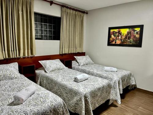 a room with two beds and a window at Imperial Inn Hospedaje Turistico in Lima