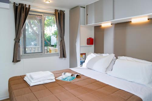 a bedroom with a large bed with a window at hu Birkelt Village in Luxembourg