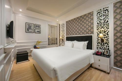 a bedroom with a large white bed and a television at Lavender Central Hotel & Spa Hanoi in Hanoi